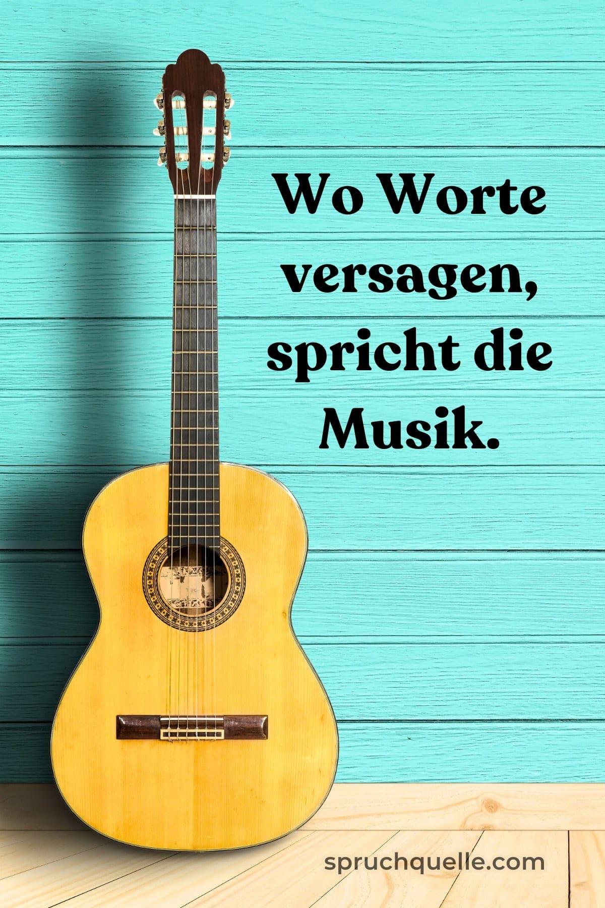 Hans Christian Andersen Eine Gitarre lehnt an einer blauen Holzwand, darunter steht „Wo Worte versagen, spricht die Musik.“